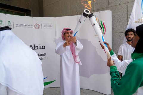 لاعبة المنتخب السعودي حنان عامري تحمل شعلة دورة الألعاب السعودية الأولى بجازان